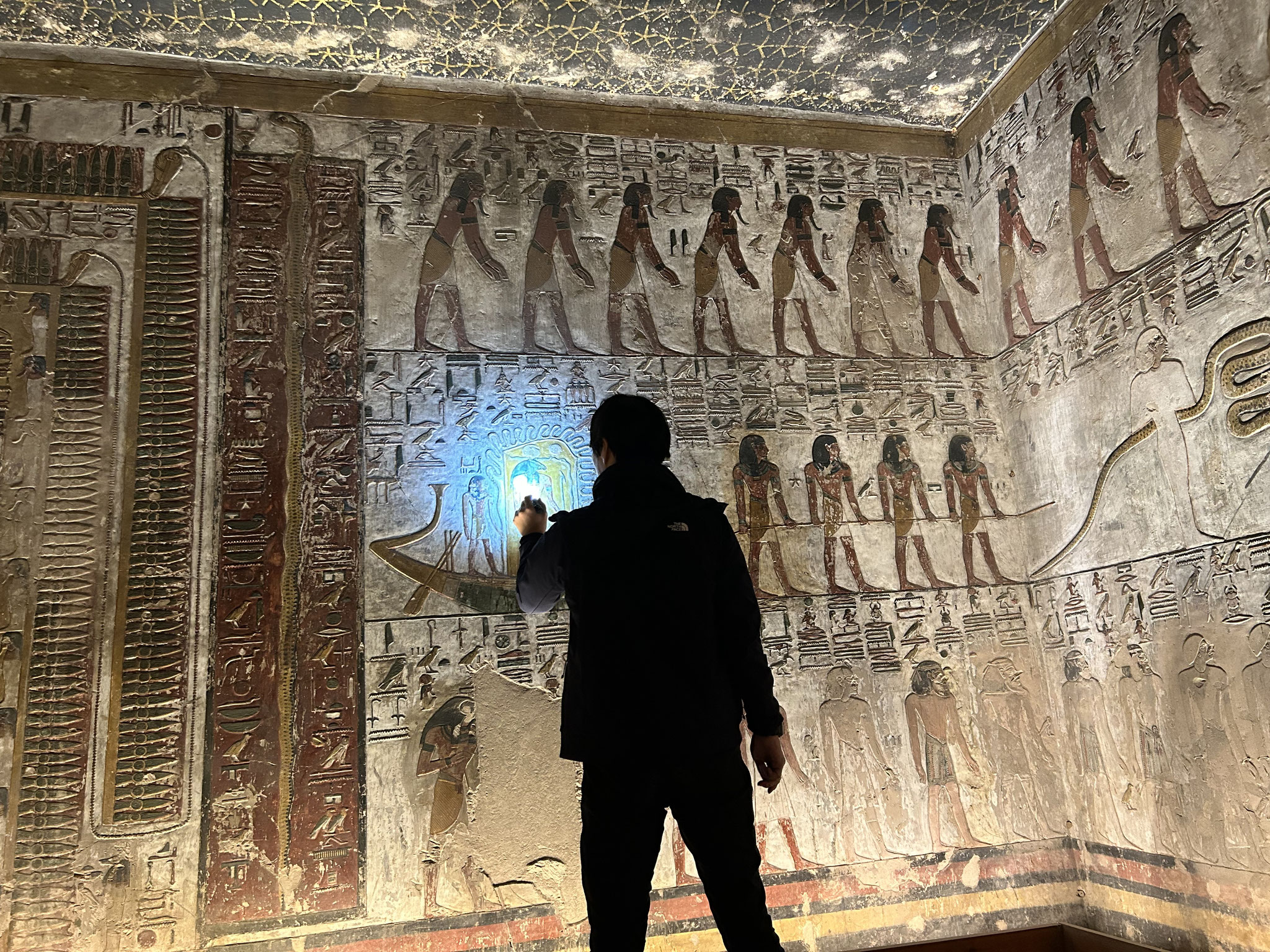 古代の墓の壁画を灯りで照らして調べる黒船満